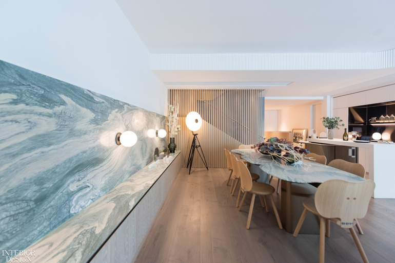 a green marble countertop matches a dining table of the same material in this home