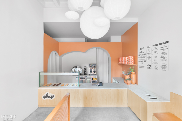 a light orange partition flanks the white and blonde neutral shades in this bakery