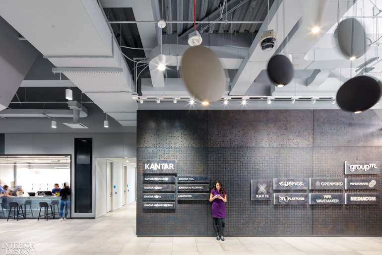 A wall of LED-backlit logos of all Kantar and GroupM divisions dominates the main reception area.