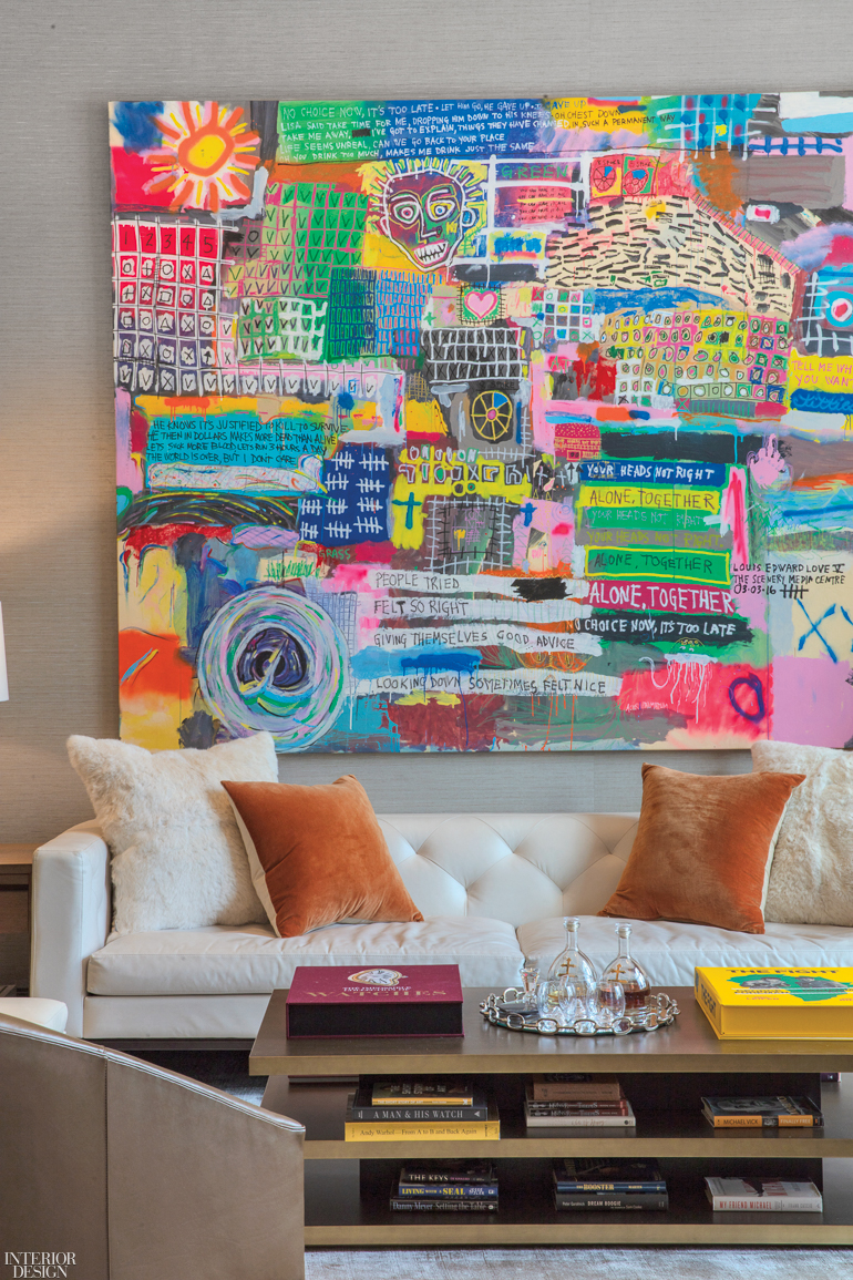 office nook with white couch, coffee table and colorful artwork