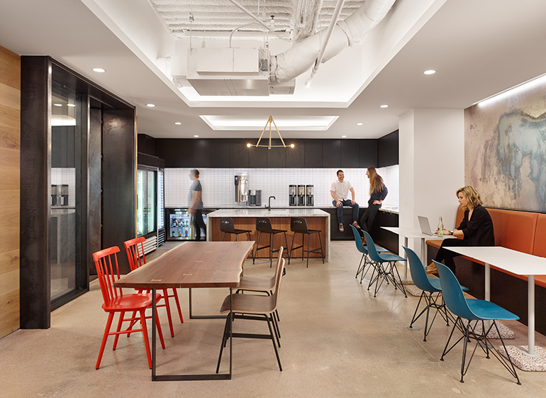 the office kitchen in Dropbox's Austin headquarters, with restaurant style seating and an island with bar stools