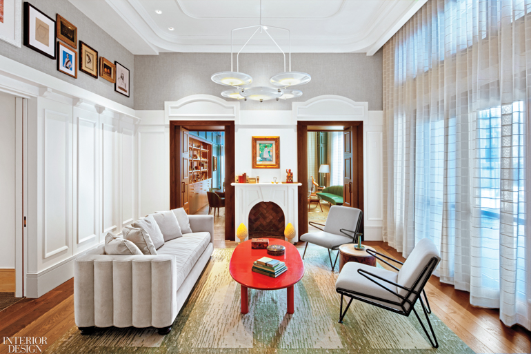 A white sofa and two chairs offer guests a place to rest in this common area with a fireplace