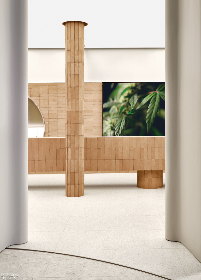 unglazed terracotta tiles wrap a column and a desk inside a cannabis shop