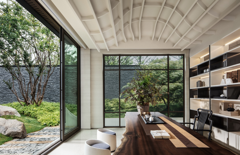 A curved white ceiling in the dining room opens to a Zen garden