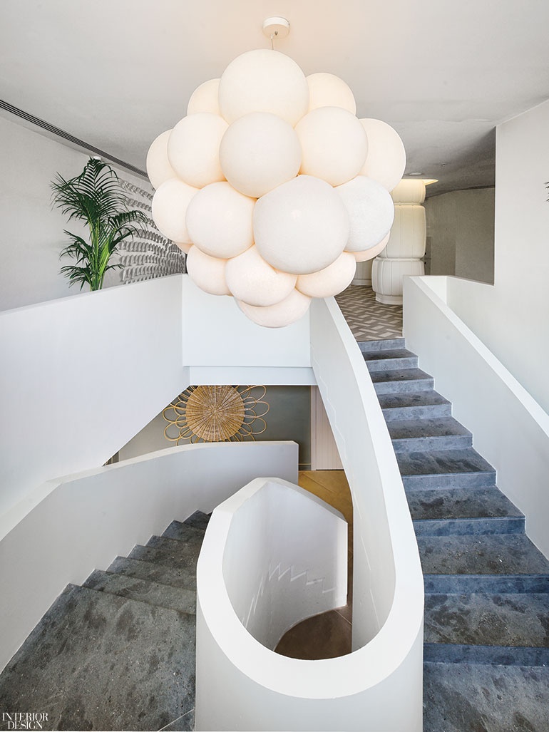 A globular lighting installation hangs above a spiral staircase.