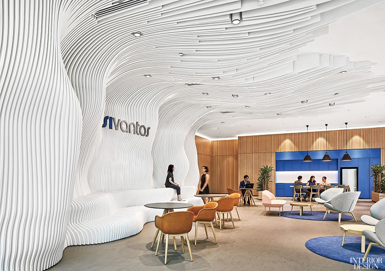 a sculptural wall next to a paneled office kitchen with blue accents