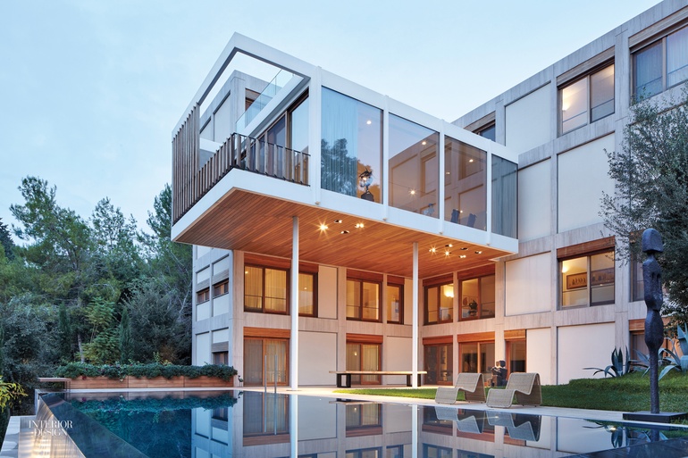 A living area juts out over the pool with a waterfall edge