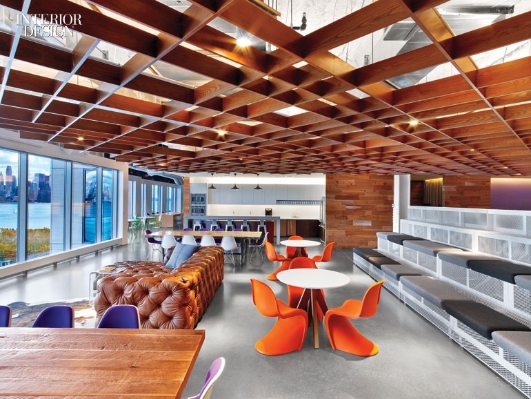 an office kitchen with a wooden hatched ceiling, stadium seating, orange curvy chairs and a leather sofa