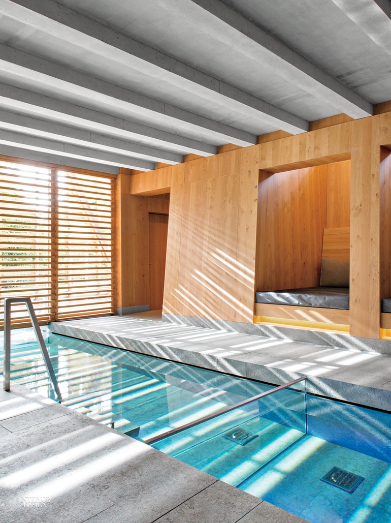 A pool inside a spa lined with wooden walls and a gray wood beam ceiling